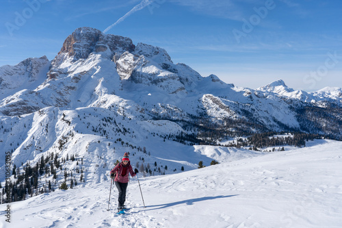 active senior woman snowshoeing from Prato Piazzo up to the Monte Specie in the three oeaks Dolomites area near village of Innichen, South Tyrol, Italy