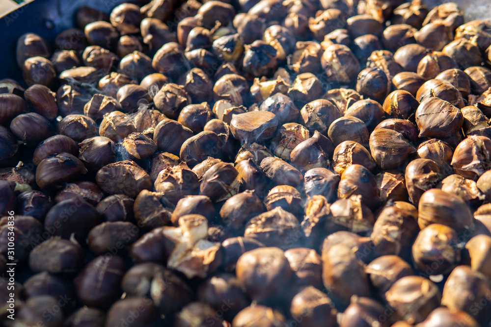 Obraz premium chestnuts roasted on the fire from a street vendor on the road in winter