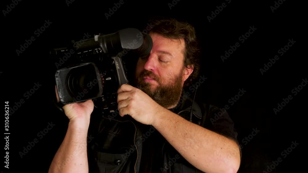 Concept idea: Bearded TV cameraman with professional broadcast video camera on black background Concept idea: Bearded TV cameraman with professional broadcast video camera on black background