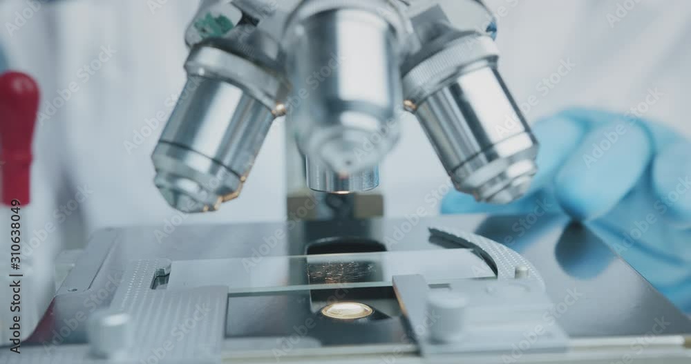 Close up shot of the scientist studies examining of test sample under the microscope in laboratory. Close up shot of the scientist studies examining of test sample under the microscope in laboratory.