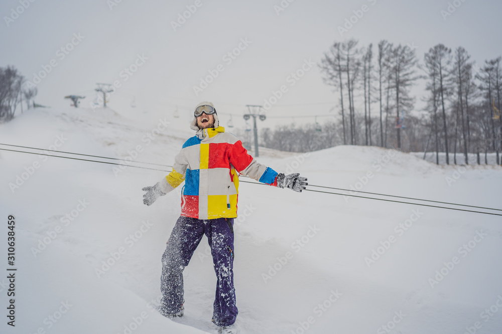 A man throws snow and enjoys the winter, outside