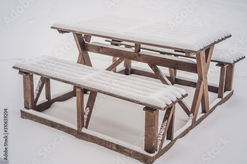 Benches in the winter city park which has been filled up with snow photo