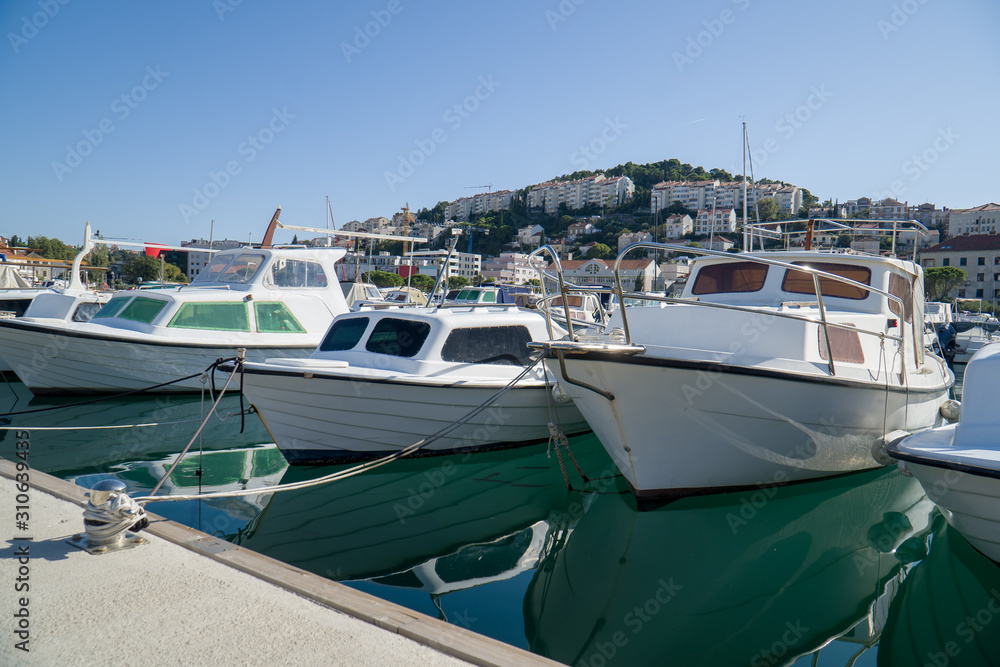 Motorboats lined up along the dockside in a little seaside town