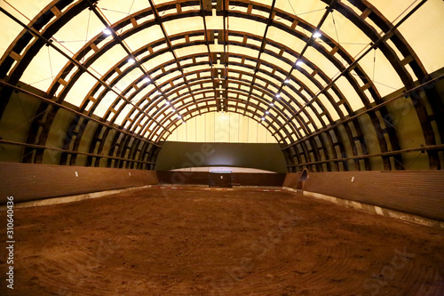 Picture of an empty indoor horse riding hall. Panoramic view in an indoor riding arena