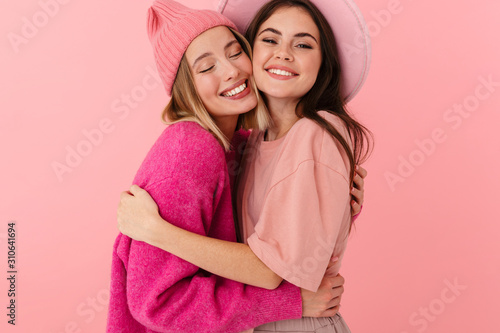 Image of two young women in girlish clothes smiling and hugging together