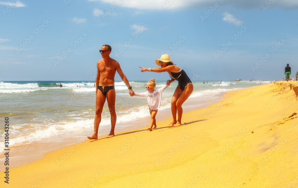 dad and mom show something far away for little daughter, sandy beach, tropics, resort vacation dad and mom show something far away for little daughter, sandy beach, tropics, resort vacation