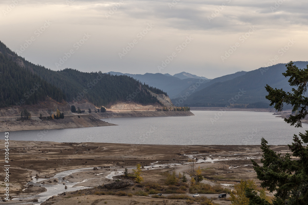 Drained lake bed creating vast open landscape with forested mountains Drained lake bed creating vast open landscape with forested mountains