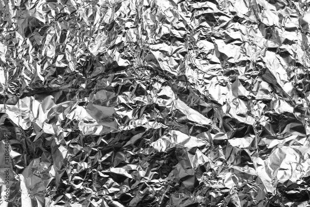 Crumpled silver foil as background, closeup view Crumpled silver foil as background, closeup view