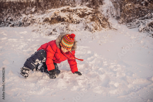 Wallpaper Mural Boy in red fashion clothes playing outdoors. Active leisure with children in winter on cold days. Boy having fun with first snow. Happy little kid is playing in snow, good winter weather Torontodigital.ca