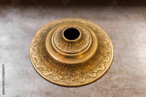 Closeup of decorative brass fixture sitting on marble table