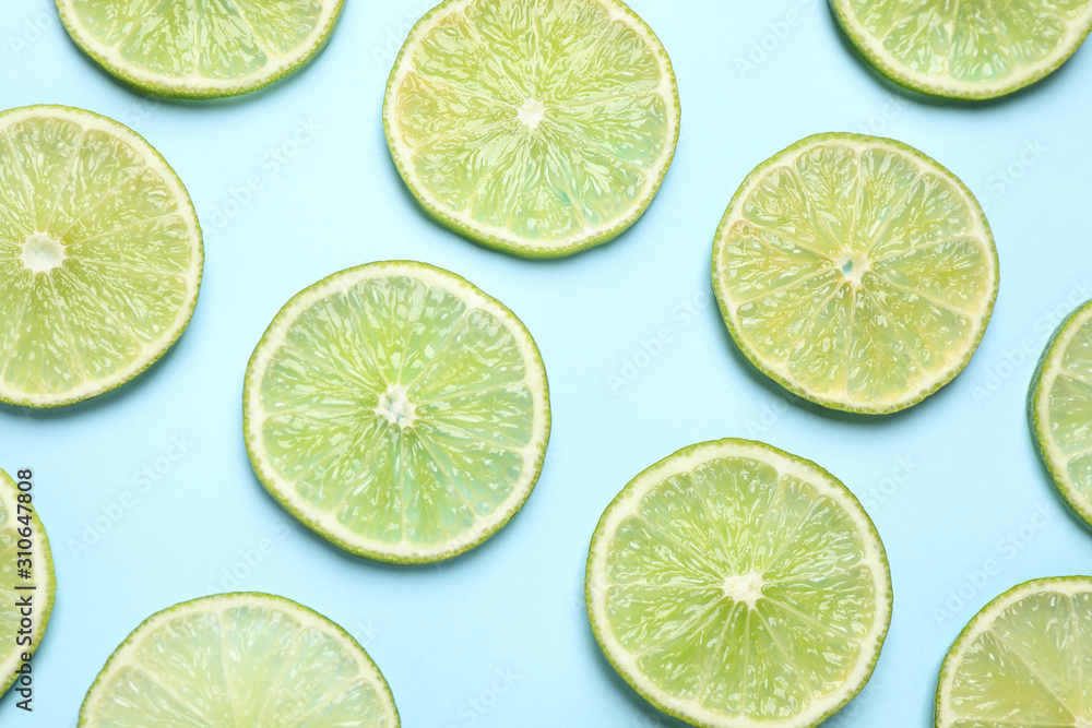 Fresh juicy lime slices on light blue background, flat lay Fresh juicy lime slices on light blue background, flat lay
