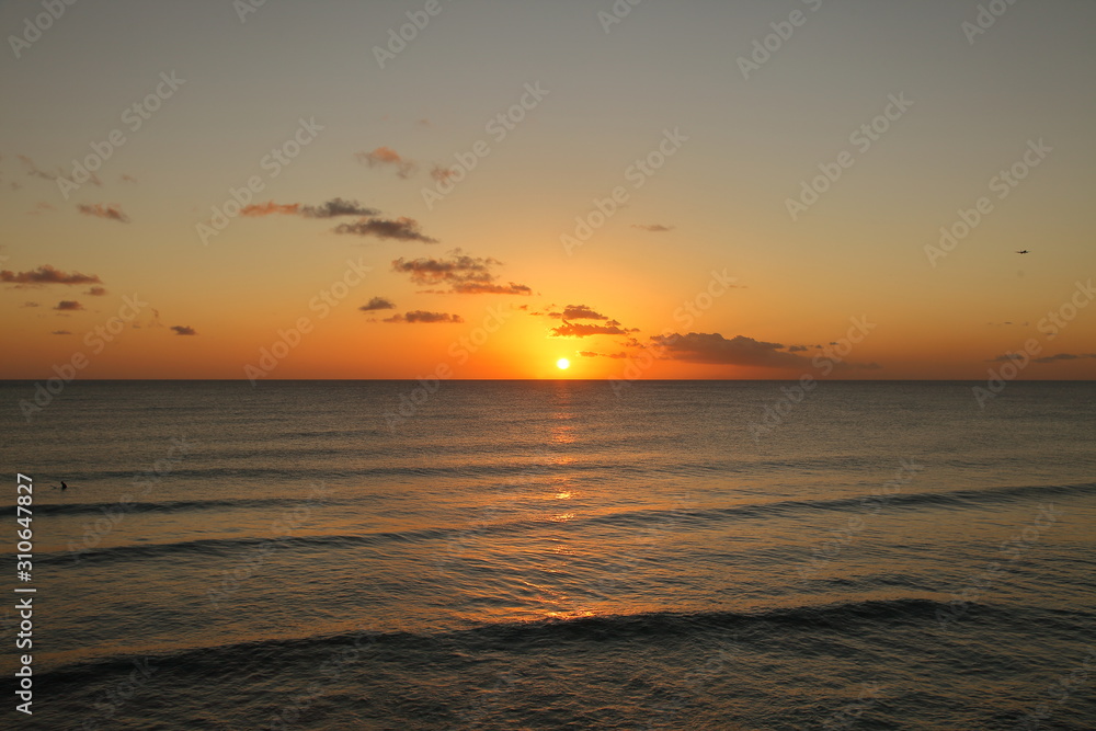 Beautiful crimson red sunset from the beach over the Caribbean Sea in Barbados, Atlantic Ocean