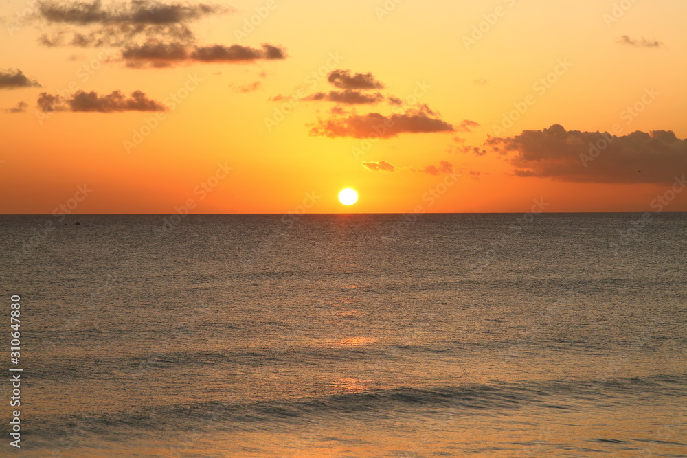 Beautiful crimson red sunset from the beach over the Caribbean Sea in Barbados, Atlantic Ocean