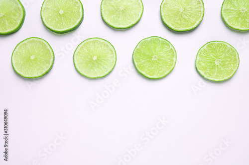 Juicy fresh lime slices on white background, top view