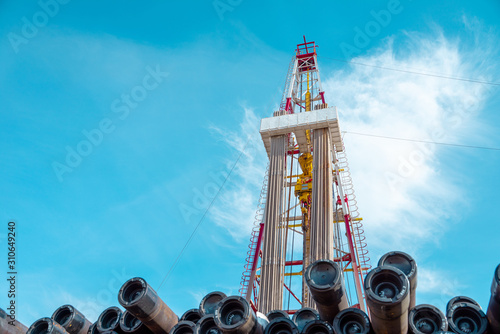 Oil and Gas Drilling Rig onshore dessert with dramatic cloudscape. Oil drilling rig operation on the oil platform in oil and gas industry.