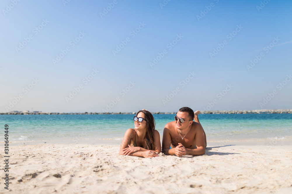 Happy young couple lying on a tropical beach Happy young couple lying on a tropical beach