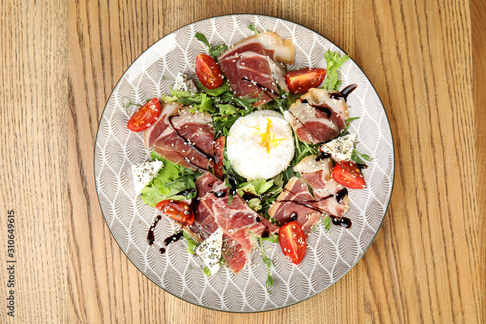 Delicious prosciutto salad with vegetables served on wooden table, top view
