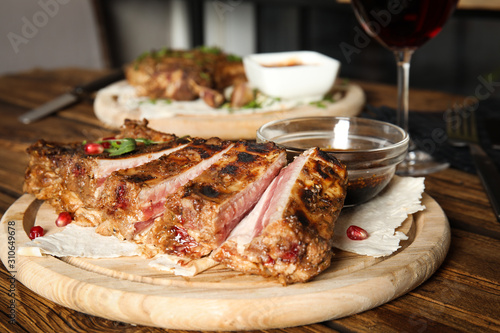 Delicious grilled ribs served on wooden table indoors