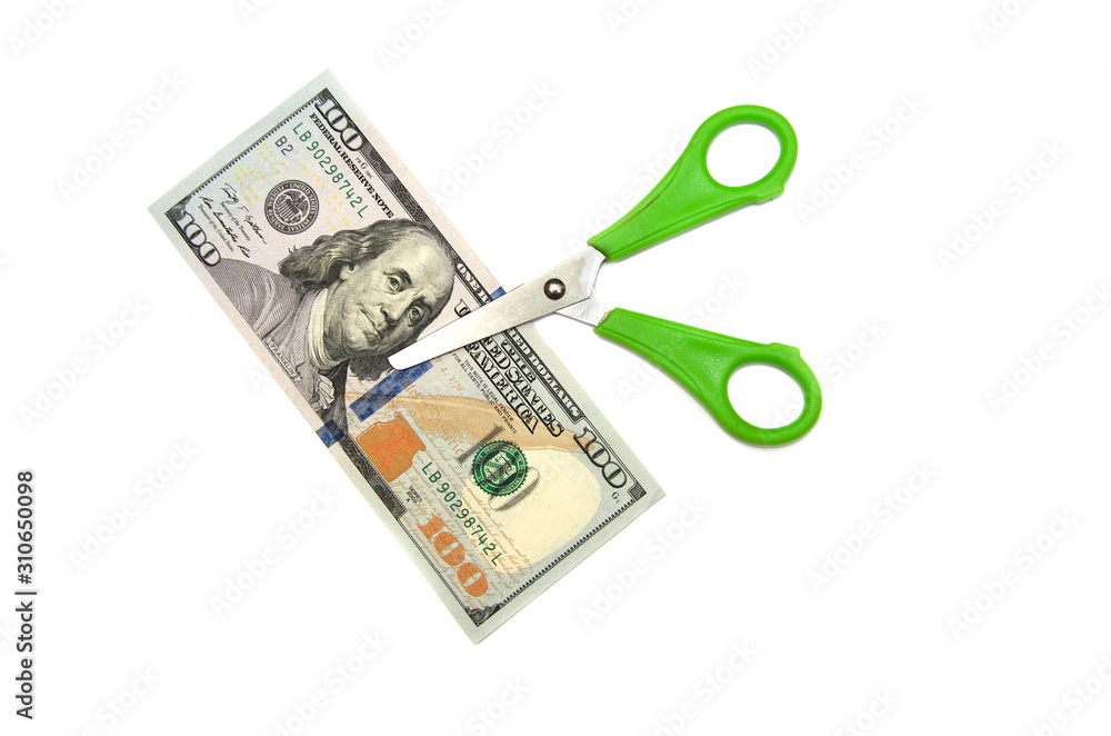 green scissors cut dollars on a white background. green scissors cut dollars on a white background.