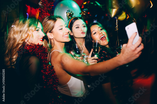Group of female friends taking selfie during New Year's party at club