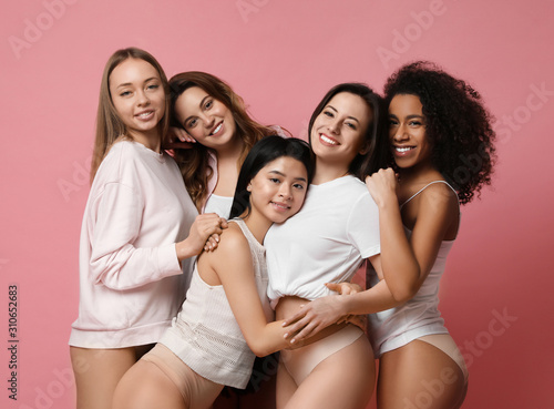 Group of women with different body types in underwear on pink background