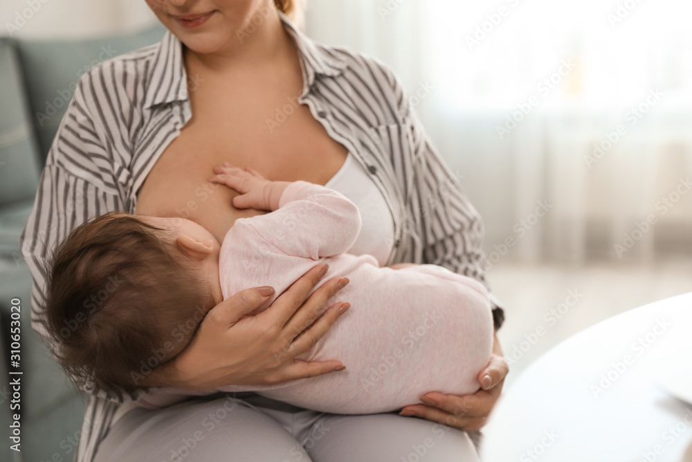 Young woman breastfeeding her baby at home Young woman breastfeeding her baby at home