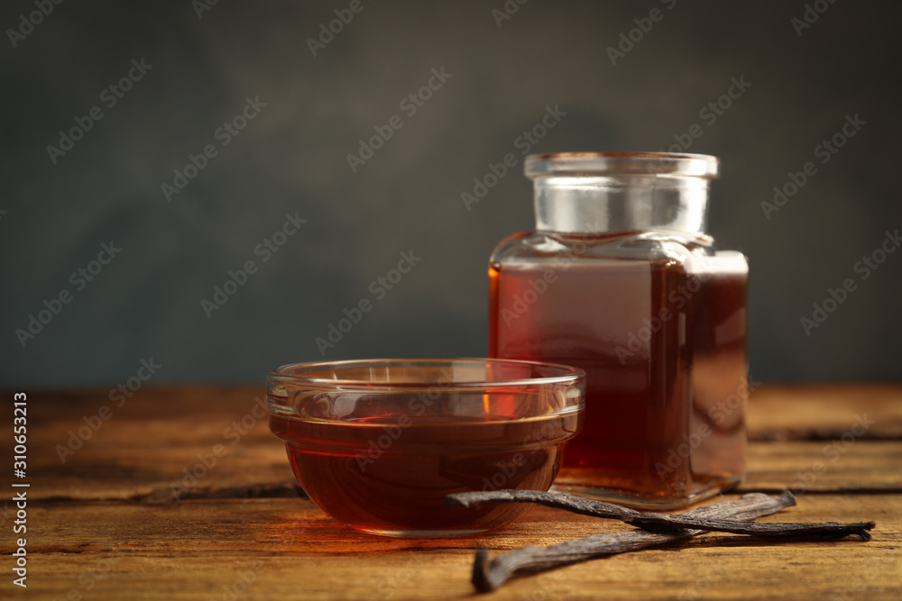 Aromatic homemade vanilla extract on wooden table Aromatic homemade vanilla extract on wooden table