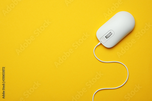 Fotografía Wired computer mouse on yellow background, top view