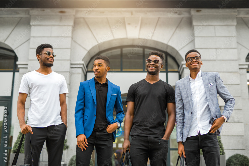 four handsome young african men on the background of the building