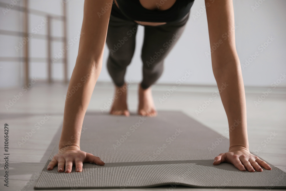 Young woman practicing plank asana in yoga studio, closeup. Phalankasana pose