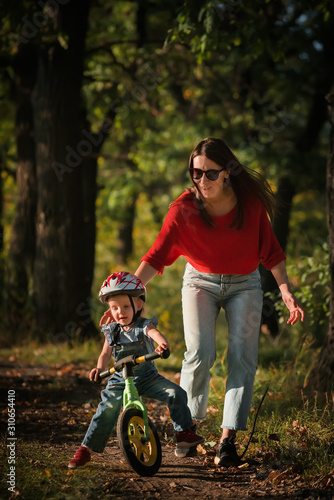 mother and daughter. Balance bike. Cycling in park.
