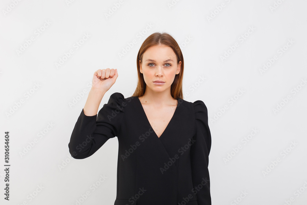 elegance woman in black dress isolated on white background. girl having serious confident look, showing clenched fist. Feminism, equality and women's liberation elegance woman in black dress isolated on white background. girl having serious confident look, showing clenched fist. Feminism, equality and women's liberation