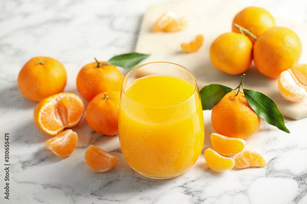 Glass of fresh tangerine juice and fruits on marble table - obrazy, fototapety, plakaty 