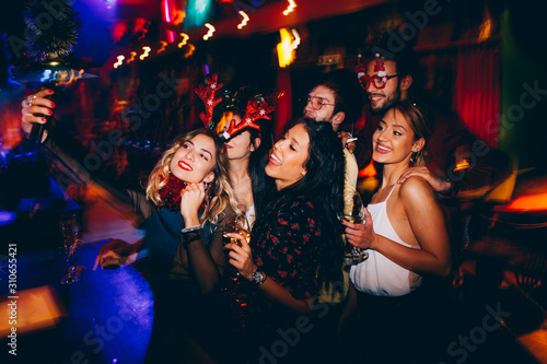Group of friends making selfie and having fun at club