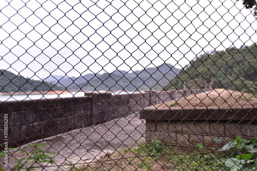 a reservoir dam behind fence and barbed wire in hong kong china