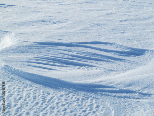 The field is covered with hardened snow with the formation of patterns