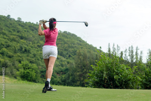 Professional golfer asian woman approach on tee off for swing and hitting golf ball and looking fairway in course. Hobby holiday and vacations in sunny morning day on club golf. Lifestyle concept