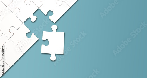 top view of jigsaw puzzle with one piece left on blue background, completing a task or solving a problem concept photo