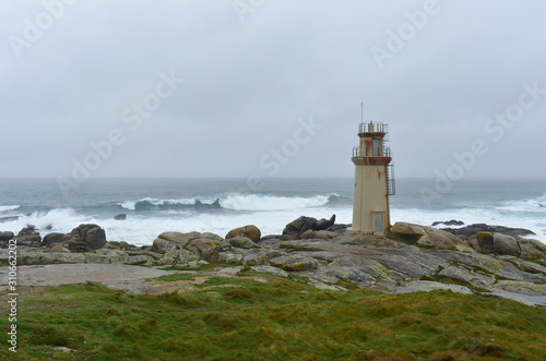 Famous Muxia Lighthouse located at Camino de Santiago pilgrimage with storm and waves. Spain.