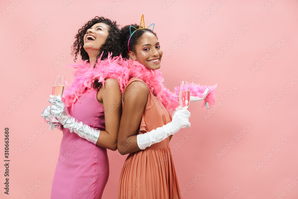 Image of joyful african american women laughing and drinking champagne Image of joyful african american women laughing and drinking champagne