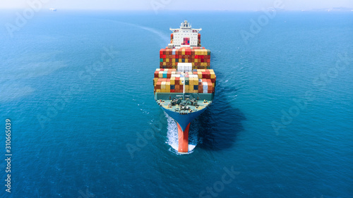 Aerial infront of cargo ship carrying container and running for export goods from cargo yard port to custom ocean concept freight shipping by ship .