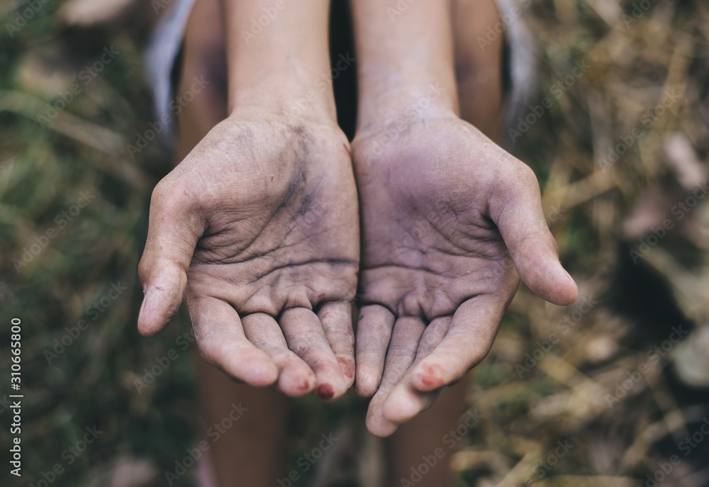 hands poor child or beggar begging you for help sitting at dirty slum. concept for poverty or hunger people,human rights,donate and charity for underprivileged children in third world hands poor child or beggar begging you for help sitting at dirty slum. concept for poverty or hunger people,human rights,donate and charity for underprivileged children in third world