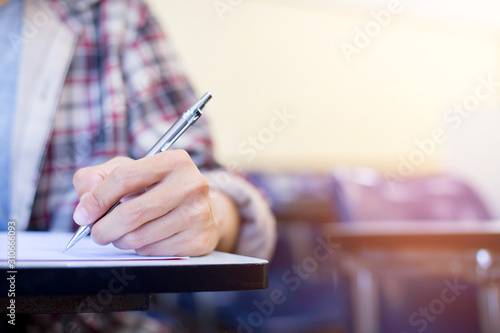 high school,university student study.hands holding pencil writing paper answer sheet.sitting lecture chair taking final exam attending in examination classroom.concept scholarship for education abroad