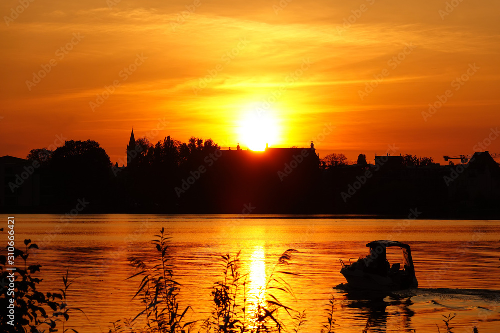 Naklejka premium Motorboot bei Sonnenuntergang