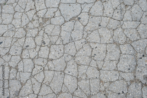 Old road background - surface of grey cracked asphalt texture