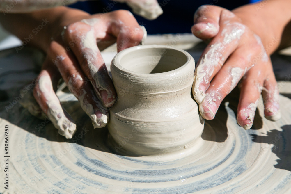 Womans hands working of ceramics on potter wheel closeup Womans hands working of ceramics on potter wheel closeup