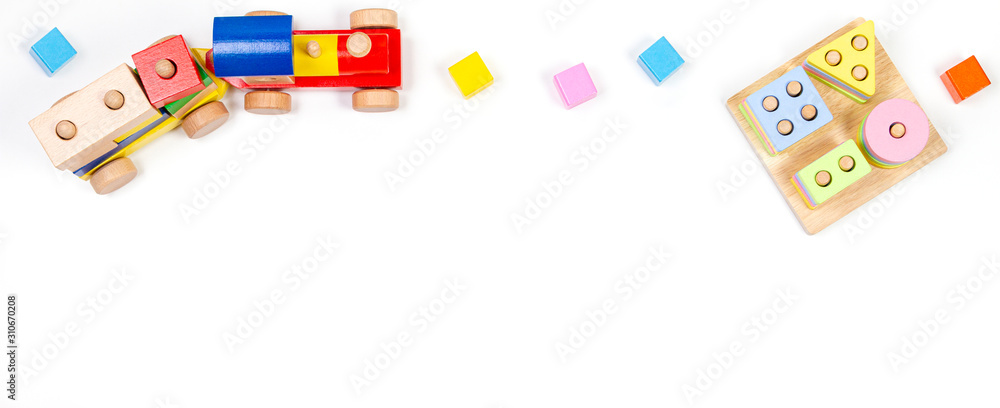 Baby kids toys background. Wooden educational geometric stacking blocks toy, wood train and colorful blocks on white background. Top view, flat lay Baby kids toys background. Wooden educational geometric stacking blocks toy, wood train and colorful blocks on white background. Top view, flat lay