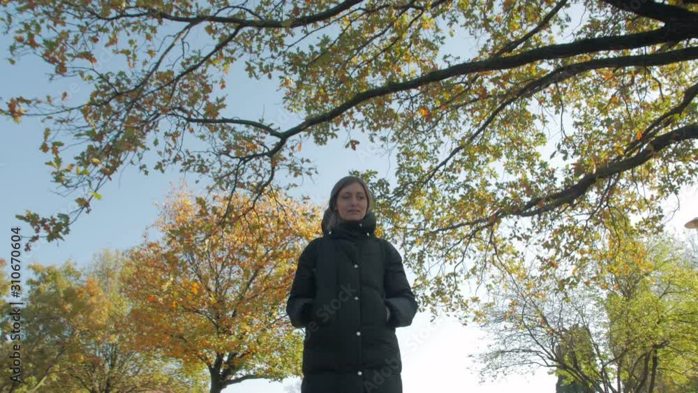 Girl walks autumn park yellow foliage serious young woman positive tracking camera movement Girl walks autumn park yellow foliage serious young woman positive tracking camera movement