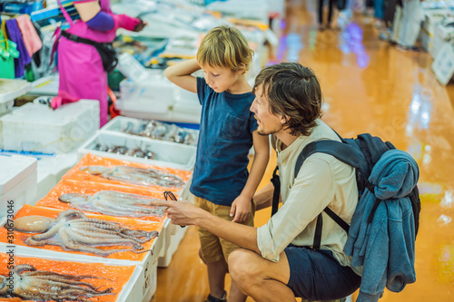 Dad and son in the Korean market. Raw seafood at Fisheries Wholesale Market in Seoul, South Korea. Traveling with children, concept