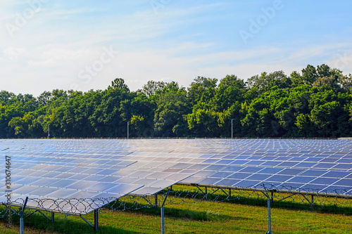 Solar panel on blue sky background. Green grass and cloudy sky.